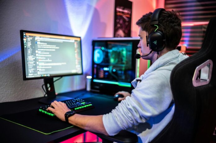 a man sitting at a computer with headphones on